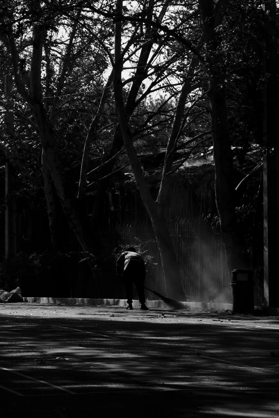 Une femme enveloppe avec soin un canapé dans un film de protection tout en préparant des cartons dans une pièce lumineuse.
